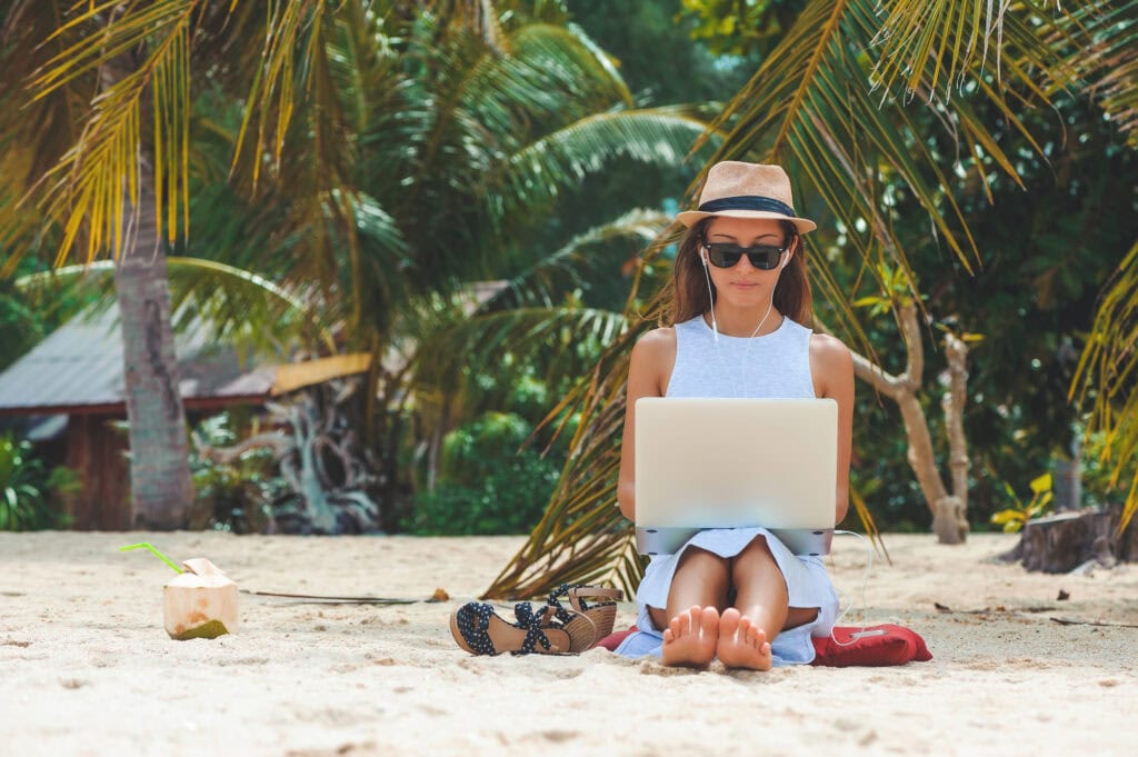 woman on beach on laptop. Instant sign up bonus no deposit