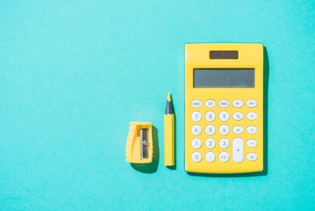 garage sale tips to make money. Garage sale tips for pricing. yellow calculator and pencil on a blue background