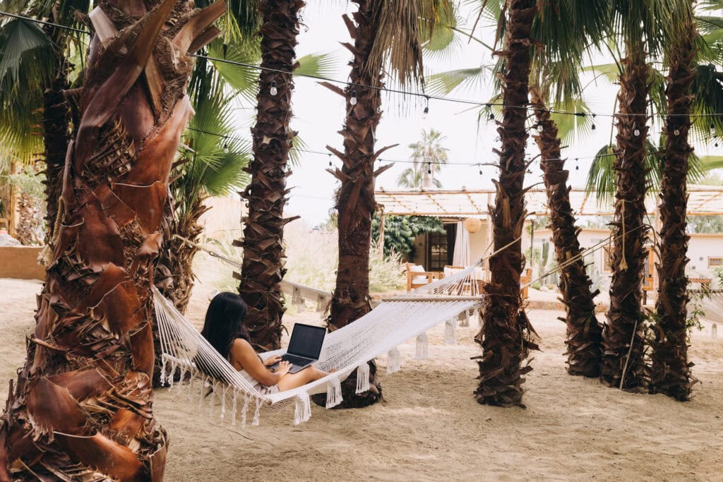 woman working on laptop on hammock - how to make $10,000 a month